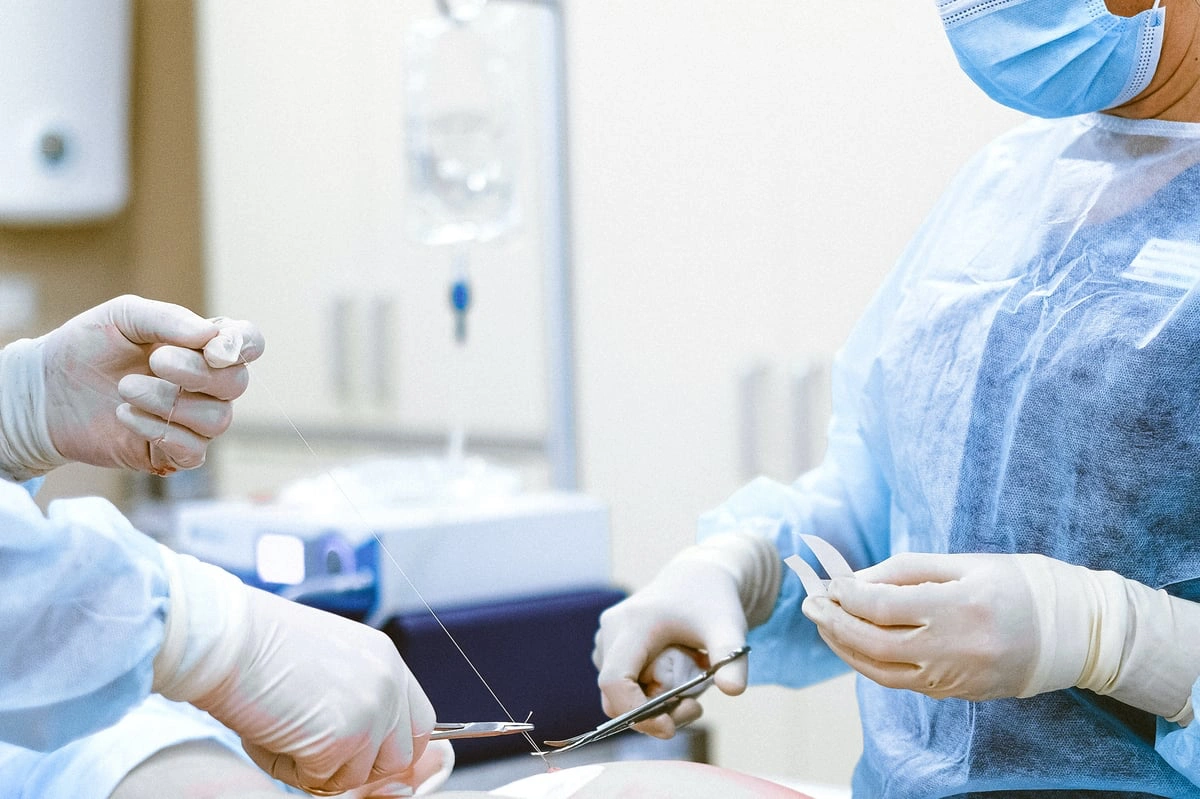 two nurses removing adhesion with scissors